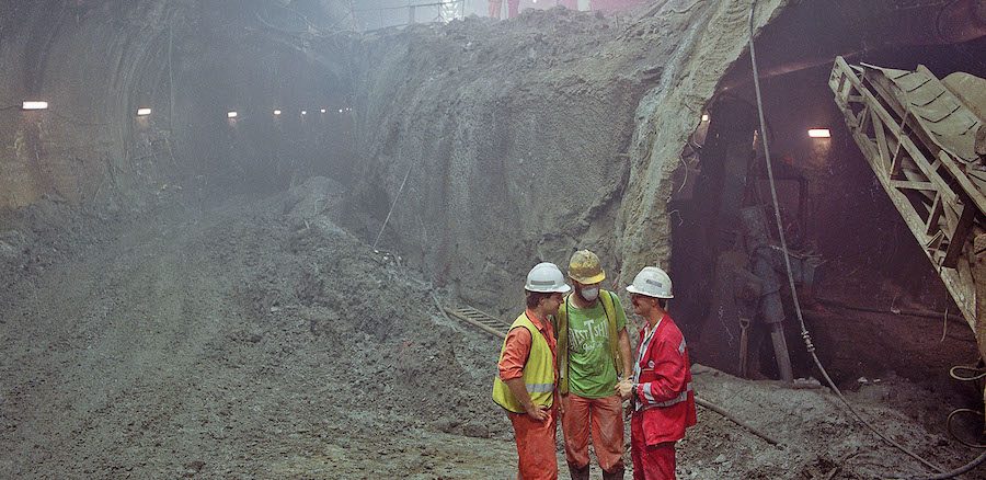 Eurotunnel monitoring engineer checks progress with contractors during construction of the Channel Tunnel UK Crossover cavern. big crane equipment