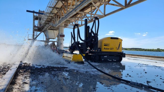 Hydrodemolition robots remove deteriorated concrete using high-pressure water without causing vibration or microcracking in surrounding material. This makes them well suited for bridge decks and dam structures where structural integrity must be preserved. Photo Credit: Conjet