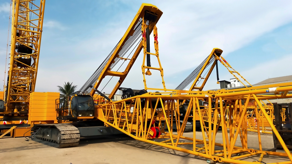 Crawler cranes use tracked undercarriages that distribute weight evenly, allowing operation on soft or uneven ground. This design provides exceptional stability for heavy lifting applications.