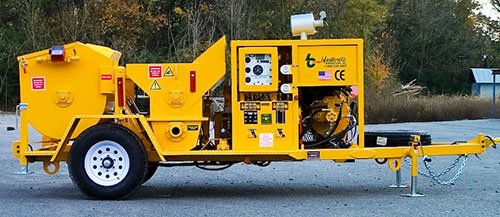 Yellow Blastcrete trailer-mounted mixer-pump staged outdoors on asphalt