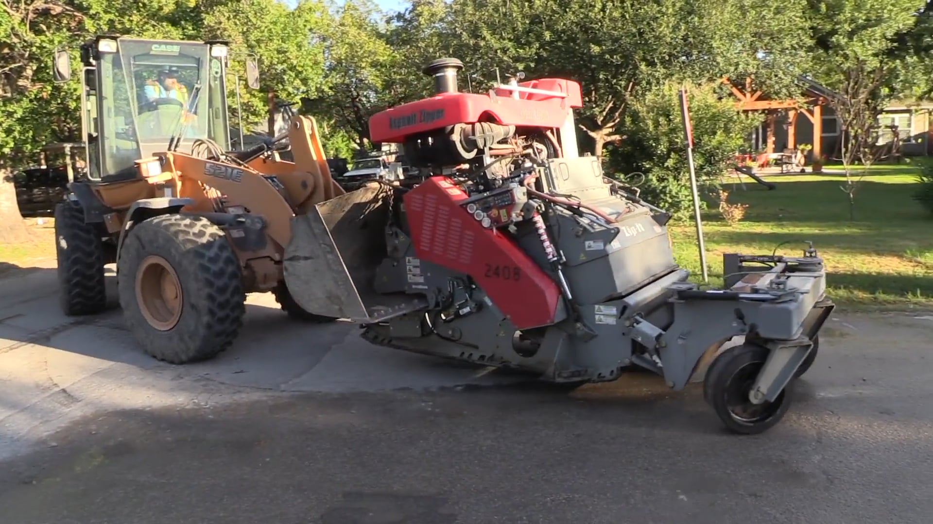 Case loader with Asphalt Zipper 2408 reclaiming asphalt on a residential street in Seguin, Texas
