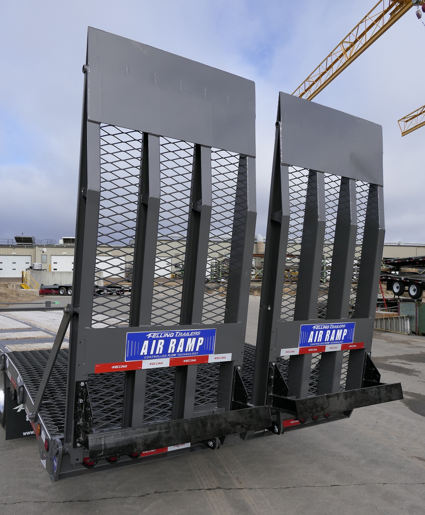 Vertical view of Felling deck-over trailer air ramps locked upright at a lot