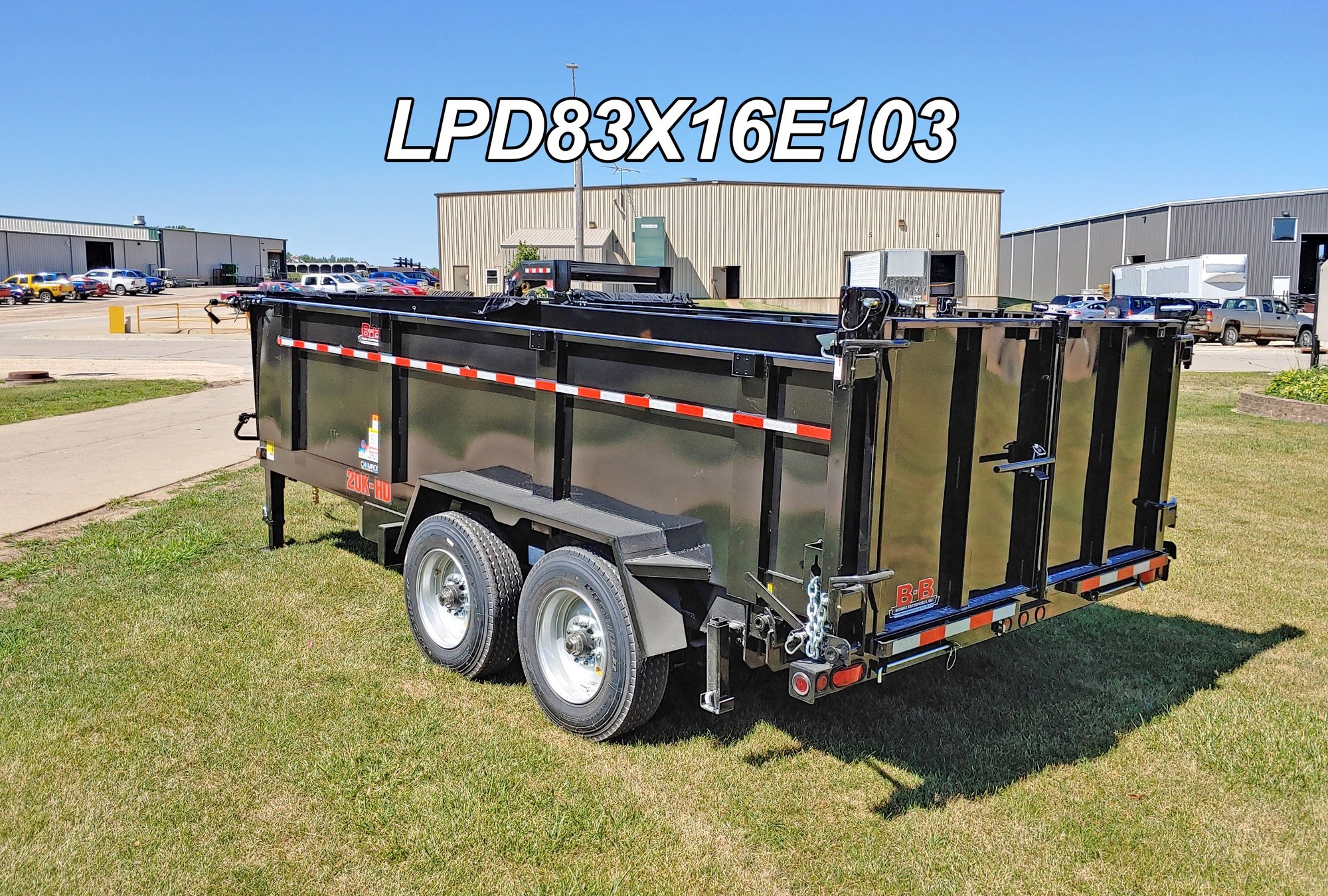 Black tandem-axle Behnke dump trailer with combination gate staged at a manufacturing lot