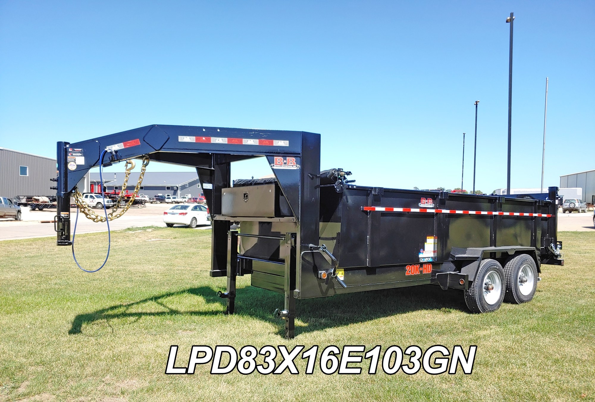 Black Behnke gooseneck dump trailer showing gate, tarp roll, and tandem axles