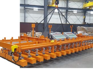 Orange multi-magnet lifting beam with selective control panels and grid of magnets against black background