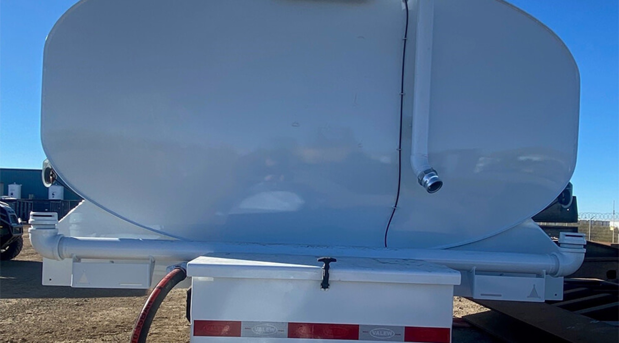 Rear view of white Valew water tank showing dual-nozzle spray bar and under-tank storage box