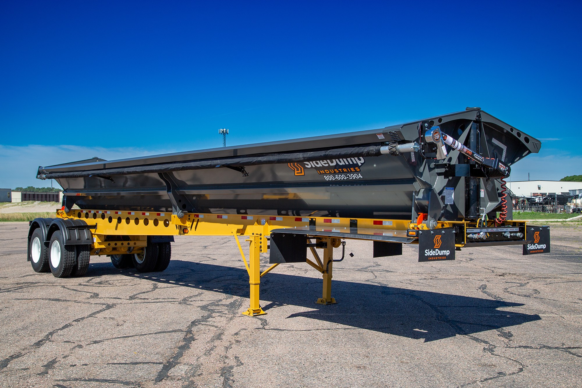 Side dump trailer configured for construction material hauling