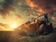 Yellow wheel loader on excavated earth with large OTR tire tread clearly visible at sunset