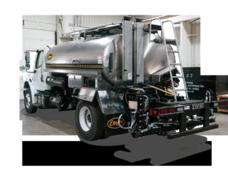 Etnyre asphalt distributor truck showing rear spray bar, nozzles, and stainless tank