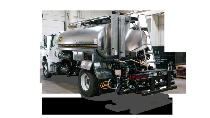 Etnyre asphalt distributor truck showing rear spray bar, nozzles, and stainless tank