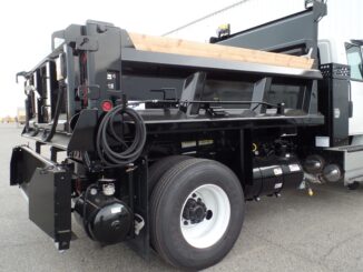 Black PB Loader asphalt patching truck showing rear emulsion tank, hose, and controls