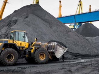 Large OTR tires on yellow rigid-frame haul trucks staged for earthmoving duty