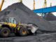 Large OTR tires on yellow rigid-frame haul trucks staged for earthmoving duty