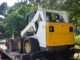 Skid steer loader chained on a tag trailer deck ready for transport