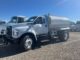 White Ford F-750 with Valew cylindrical water tank body parked on a gravel lot