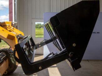 Skid steer with high-dump bucket in extended dump position for truck loading clearance