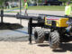 Laser-guided boom screed placing commercial flatwork for FF/FL control