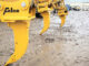 Yellow Felco excavator ripper shanks in equipment yard